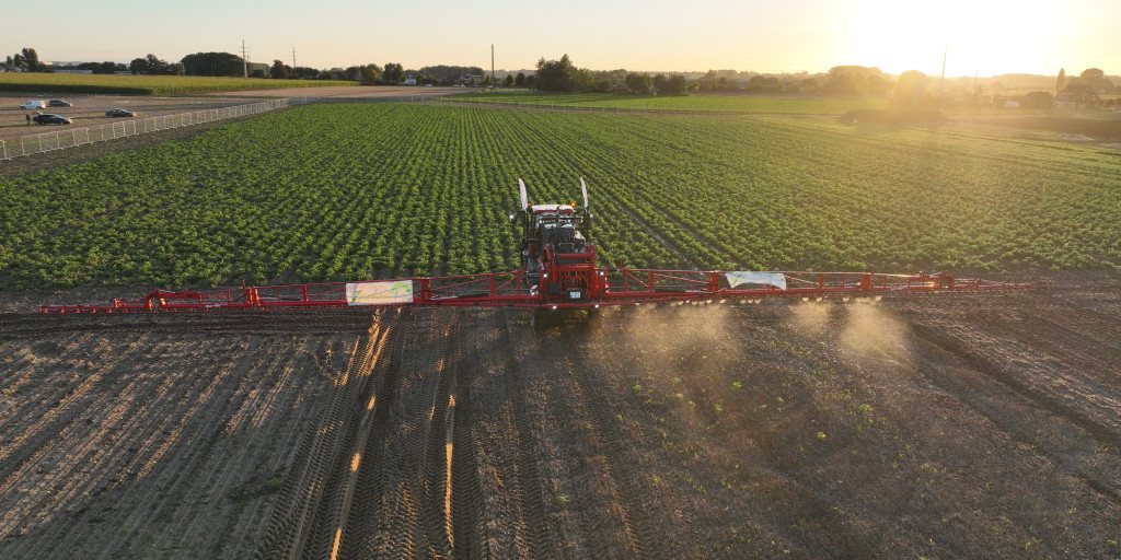 Moderne tractor met spuit op een akker